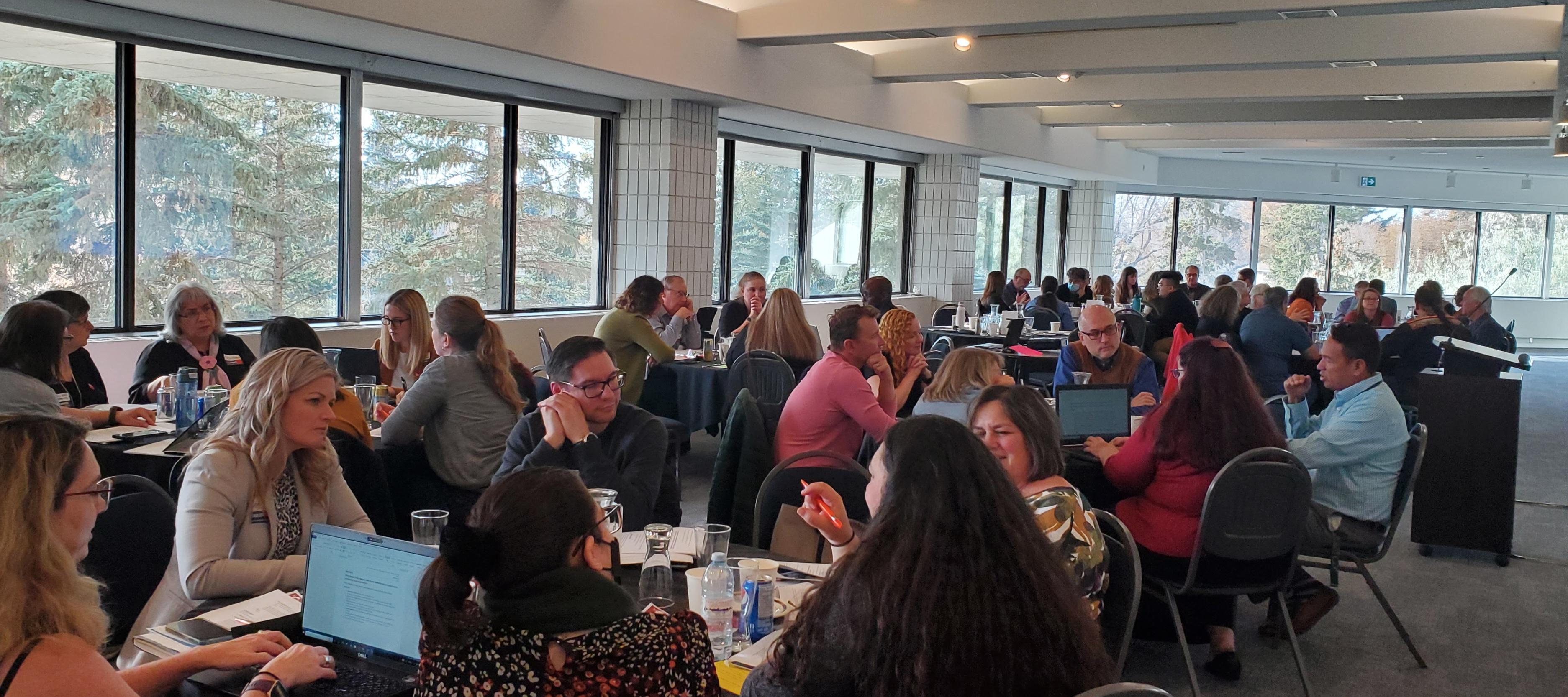 A crowd of people sitting at tables at an ECO gathering in 2022.