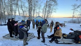 A photo of participants and facilitators in the winter camp at Kenosee Lake, smiling at the camera.