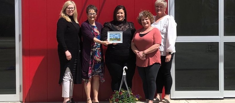 A photo of a volunteers receiving an award, posing with Rivers West District staff.