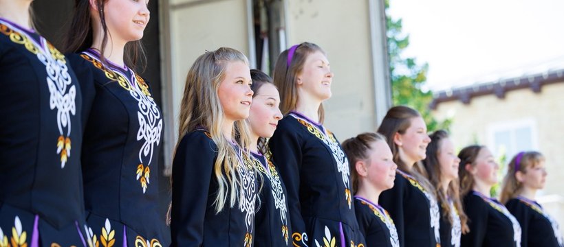 A photo of a line of young Prairie Gael School of Irish Dance dance students at a performance.