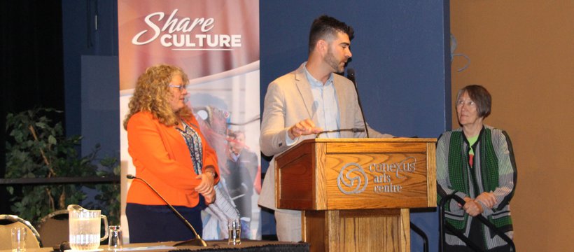 Joanne McDonald, James Rose and Pat Grayston stand near a podium.