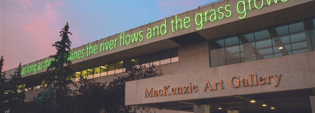A photo of the entrance of the MacKenzie Art Gallery, with a neon green sign that reads “as long as the sun shines the river flows and the grass grows.”