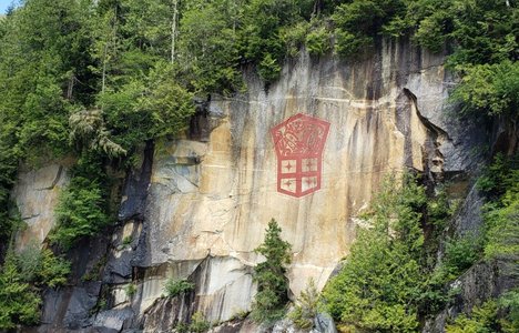 Marianne Nicolson, Painting on a cliff face in red paint.