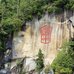 Marianne Nicolson, Painting on a cliff face in red paint.