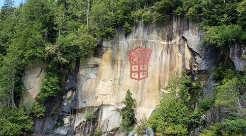 Marianne Nicolson, Painting on a cliff face in red paint.