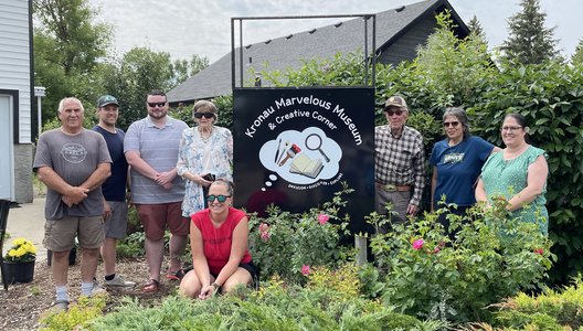 Photo of a group of people gathered around the Museum's sign.