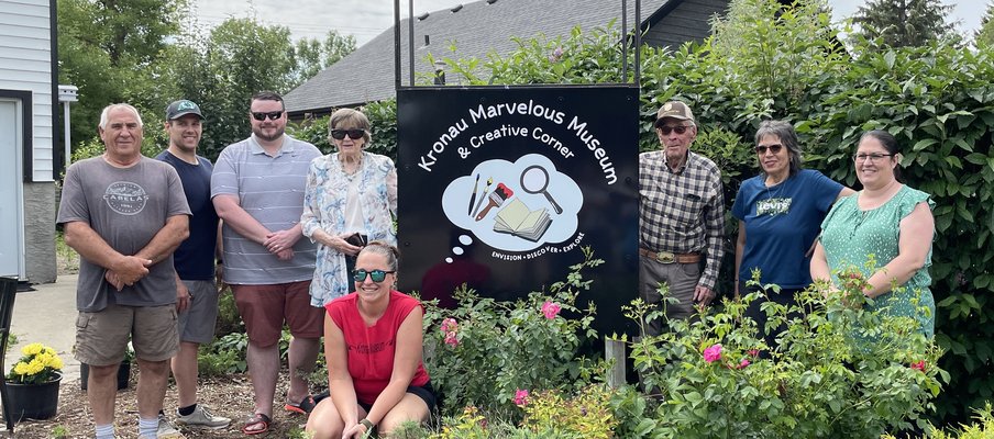 Photo of a group of people gathered around the Museum's sign.