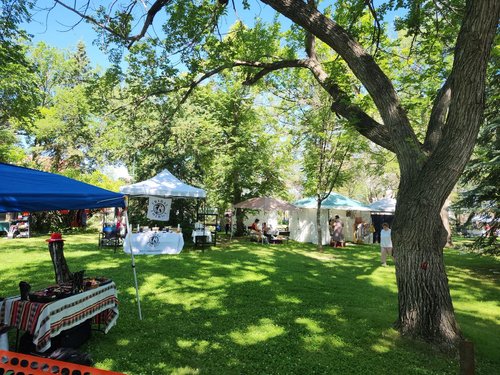 People browsing booths outdoors in a park
