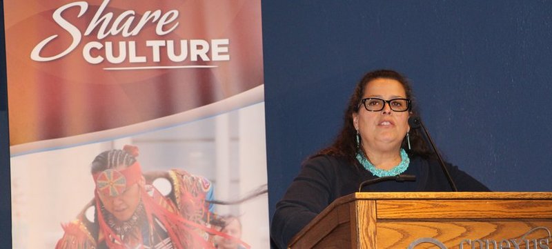 Tracey Lindberg stands at a podium.