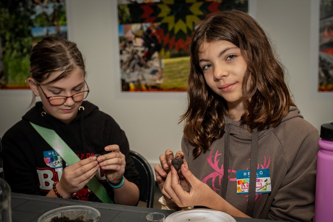 Two kids working with clay at a workshop
