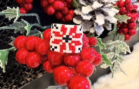Image of a beaded ring with berries, pinecones and leaves
