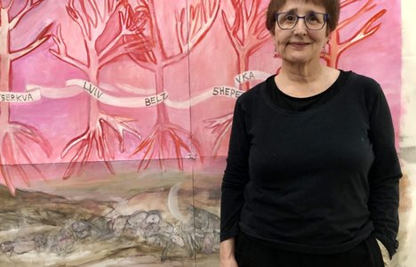 Photo of artist standing next to their painting