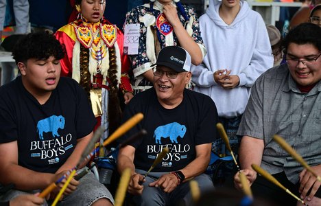 Three men beating a drum
