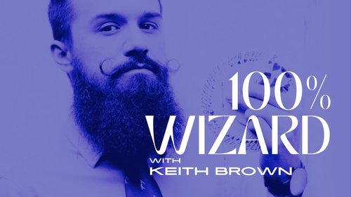 Bearded Magician Keith Brown holds a fan of playing cards near his face. He's seen from the chest up. The entire image is in blue. There is white text overlayed on top that says 100% Wizard with Keith Brown