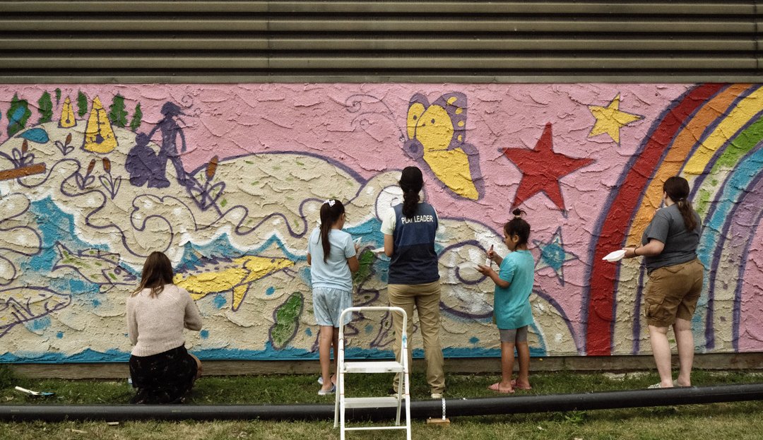 A photo of youth helping create the Midtown Mural in Prince Albert.