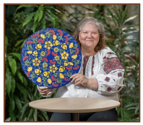 Artist Dawna Hawrysh holds one of her Petrykivka paintings.