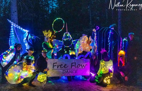Photo of glowing dancers with sign that says Free Flow Dance.