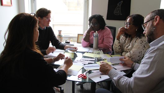Group of SaskCulture Staff sitting at a table discussing a exercises.