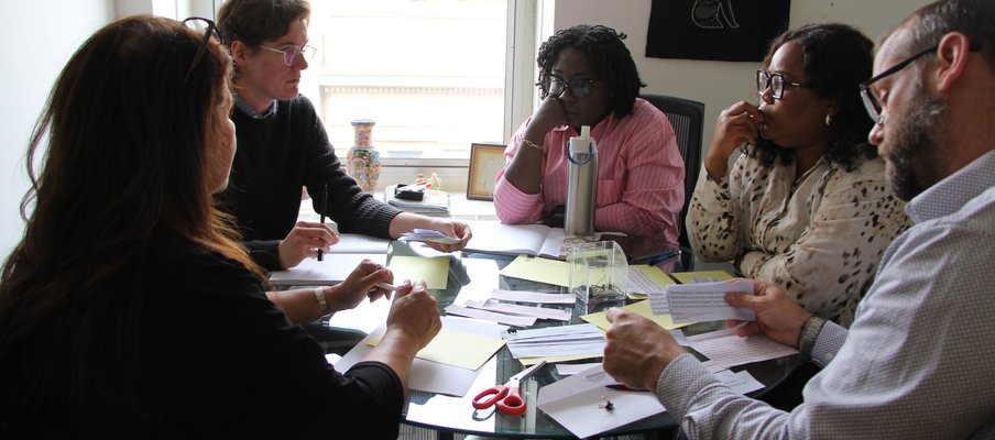 Group of SaskCulture Staff sitting at a table discussing a exercises.