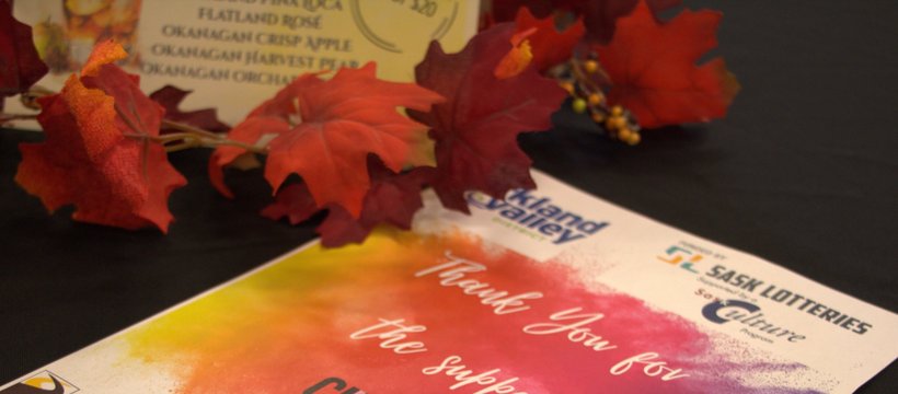 Image of a poster on a table with leaves and the SaslCulture and SaskLotteries logo