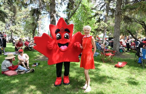 Photo of LG McIntyre and a Maple leaf mascot, Salut standing outside at Canada Day.