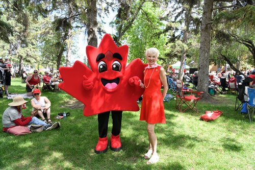 Photo of LG McIntyre and a Maple leaf mascot, Salut standing outside at Canada Day.
