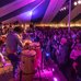 Photo of band preforming on the stage with a standing crowd listening