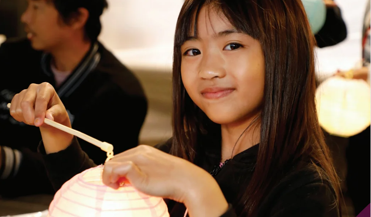 Cover image of the Strategic plan with an image of a girl making a paper lantern.