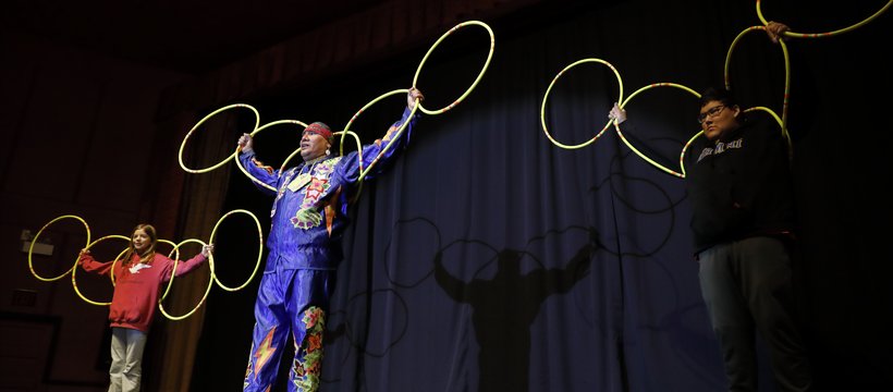 Hoop dancer Terrence Littletent performing with two young people