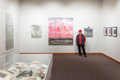 Image of Betsy Rosenwald standing next to one of her painting's titled Homage in the museum's gallery; image credit to Carey Shaw