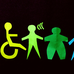 Paper cut-outs of people with various disabilities from amputees, deaf and blind, invisible disabilities. Images are cut-outs and in various bright colours