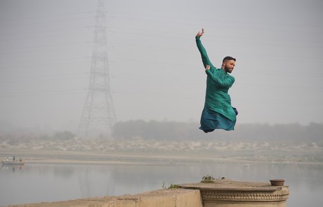 a dancer leaps into the air on a pier