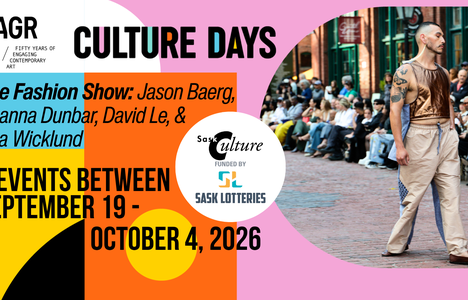 An Indigenous man walks down an outdoor runway. He's wearing long white tassel earrings, a bronze metallic leather vest, beige and blue pants, and brown loafers.