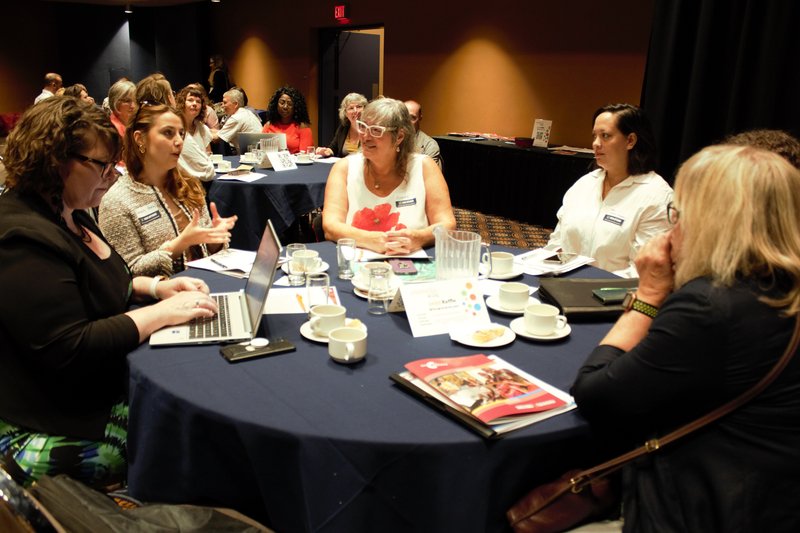 People sitting around a table talking at the 2023 AGM.