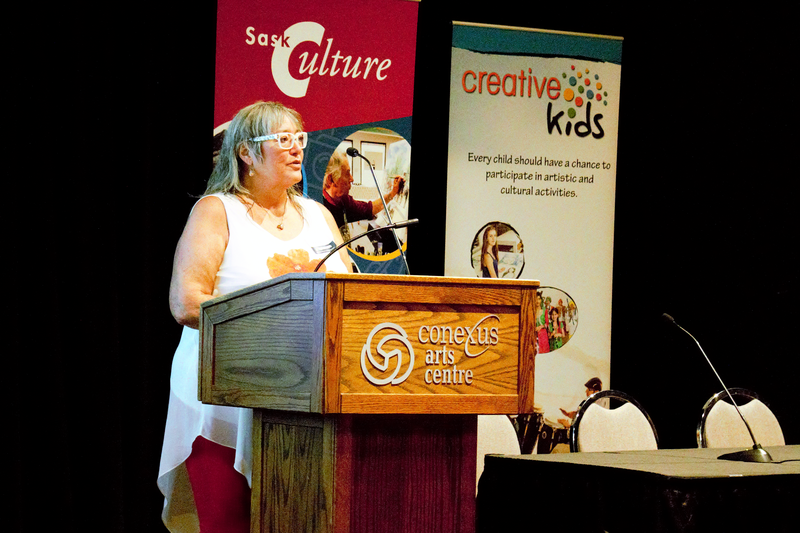 A photo of Yvonne Hotzak speaking at a podium at the 2023 AGM.