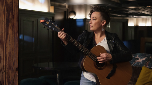 photo of Olle playing a guitar in a darkened room
