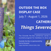 A dark blue and gold speckled paper jug stands in a flower bed