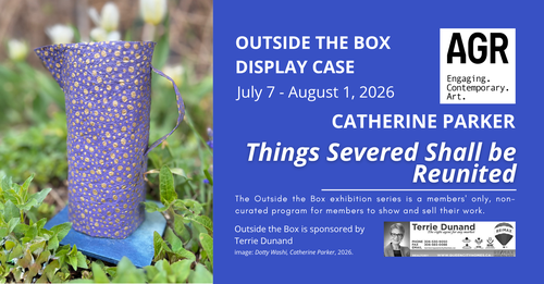 A dark blue and gold speckled paper jug stands in a flower bed