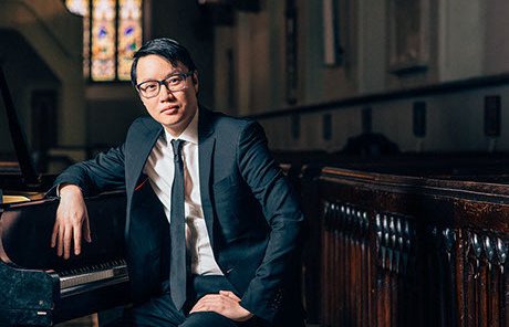 concert artist at the grand piano in a historic church, about to give a recital