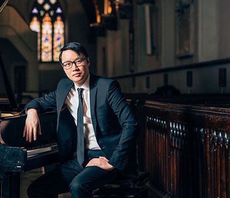 concert artist at the grand piano in a historic church, about to give a recital