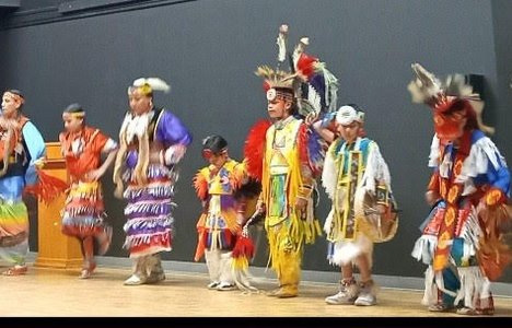 Photo of a Indigenous group preforming in traditional dress.