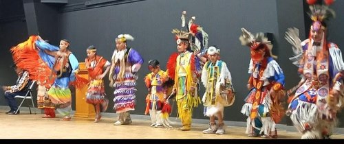 Photo of a Indigenous group preforming in traditional dress.