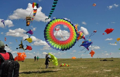Image of many people flying multiple kites